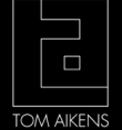 TOM AIKENS logo